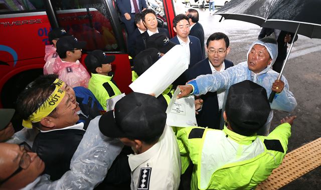 7일 제주도에 대한 국회 국토교통위원회의 국정감사 당일 제주도청 정문에서 대기하며 제2공항 반대 집회를 하던 제주 제2공항 성산읍 반대대책위원회 주민들이 버스에서 내린 국회의원들에게 제2공항 건설 관련 반대 건의문을 전달하고 있다. 연합뉴스