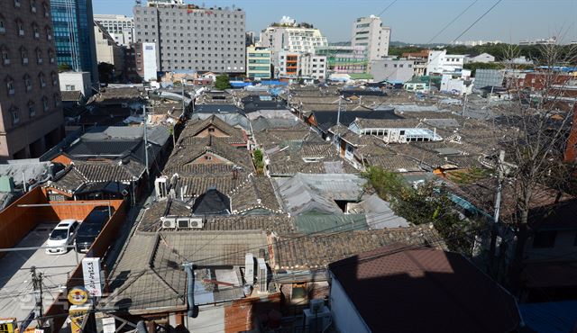 13일 인근 빌딩에서 내려다본 서울 종로구 익선동 한옥마을 전경. 방수포로 엉성하게 기와를 덮은 한옥집이 많이 보인다. 서울시는 낙후된 익선동 한옥마을을 재개발하는 대신 보존하기로 결정했다. 신상순선임기자 ssshin@hankookibo.com<지금 이곳에선> 익선동의 어제와 오늘 그리고 내일