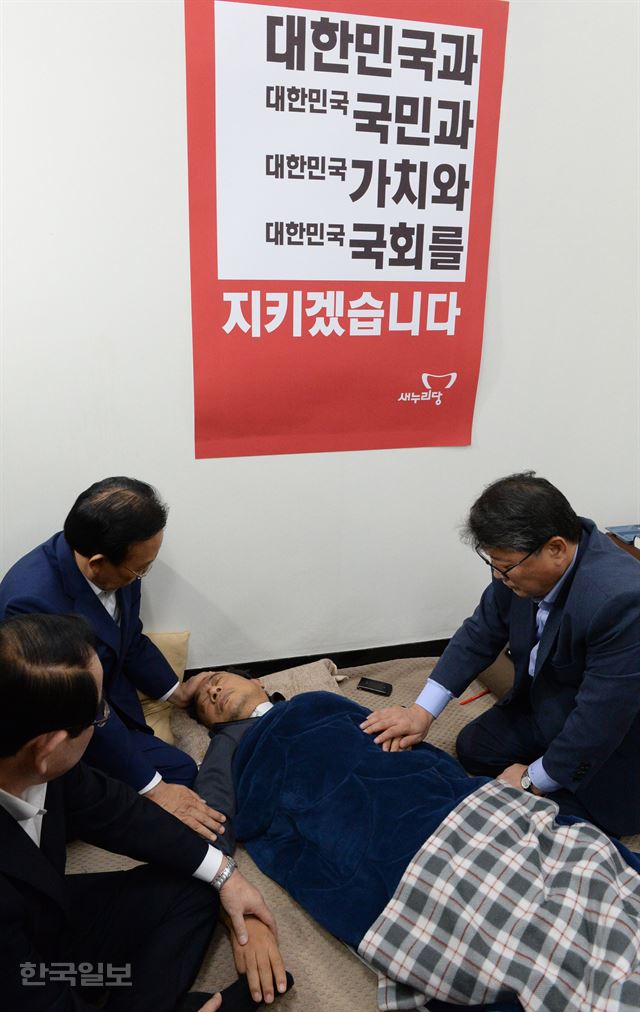 새누리당 관계자들이 지난 2일 단식투쟁 중인 이정현 당 대표를 찾아 위로하고 있다. 전형적인 종교화의 구도다. 한국일보 자료사진