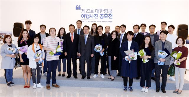 19일 오전 서울 서소문 대한항공 빌딩 일우 스페이스에서 열린 '제23회 대한항공 여행사진 공모전’ 시상식과 전시회에서 지창훈(왼쪽에서 열번째) 대한항공 사장과 이준희(여덟번째) 한국일보 사장, 조현민(열한번째) 통합커뮤니케이션실 전무, 대상수상자 김민수(열두번째) 등이 심사위원 및 수상자들과 기념촬영을 하고 있다. 홍인기 기자