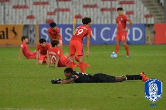 U-19 대표팀 선수들이 20일 사우디와 AFC 챔피언십 조별리그 최종전에서 패해 8가 진출이 좌절된 뒤 허탈해하고 있다. 반면 극적으로 8강에 오른 사우디 골키퍼(아래)는 엎드려 환호하고 있다. 대한축구협회 제공