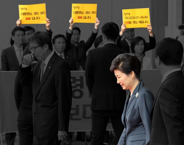 박근혜 대통령이 국회에서 시정연설을 끝내고 김무성 새누리당 대표등 지도부의 안내를 받은며 퇴장하고 있다. 뒤쪽에서 정의당 의원단이 국정화 반대 피켓시위를 벌이고 있다. 2015.10.27 고영권기자