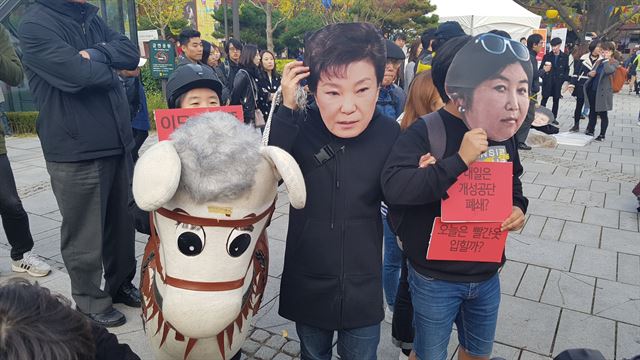 29일 서울 동숭동 마로니에 공원에서 열린 박근혜 대통령 규탄 집회에서 참가자들이 박 대통령과 최순실씨를 풍자하는 가면을 쓰고 있다.