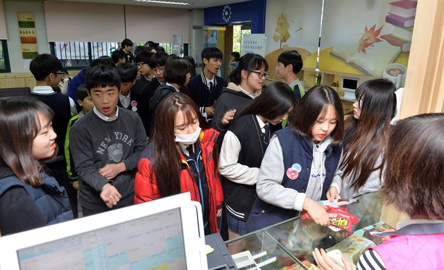 3일 서울 동작구 국사봉중학교 학생들이 점심 시간에 학교협동조합이 운영하는 매점 ‘그냥가게’에서 간식을 구매하고 있다. 판매원이 학부모들이다. 신상순 선임기자 ssshin@hankookilbo.com