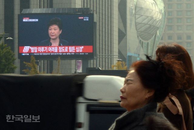 4일 오전 박근혜 대통령의 대국민 사과 방송이 방영되고 있는 광화문 광장을 시민들이 지나가고 있다. 신상순 선임기자 ssshin@hankookilbo.com