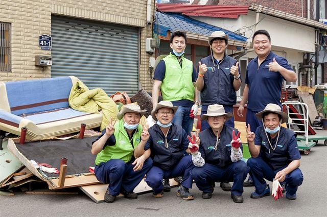 인천 화수부두마을에서 집수리 자원봉사 활동을 벌인 두산인프라코어 직원들이 기념촬영을 하고 있다. 두산인프라코어 제공