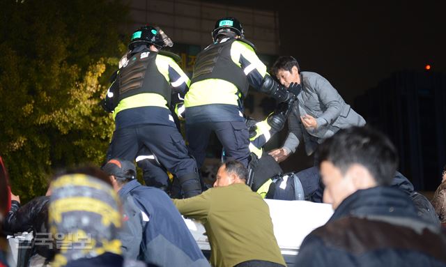 [161112-33] [저작권 한국일보]12일 오후 서울광장, 광화문 광장을 비롯한 도심 곳곳에서 열린 박근혜 대통령 퇴진을 촉구하는 민중총궐기대회에서 한 남자가 이 내자동 교차로 입구에서 경찰과 대치 중 차벽 위로 올라가고 있다. 집회에 모인 시민들은 이들이 폭력 행위를 조장 한다고 판단 이들에게 내려올것을 요구 하고 평화시위 분위기를 이어 갔다. 신상순선임기자 /2016-11-13(한국일보)