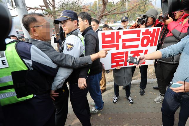 14일 오전 '박정희 전 대통령 탄생 99주년 숭모제'가 열린 경북 구미시 상모사곡동 박 전 대통령의 생가 앞에서 한 시민이 '박근혜 퇴진'이란 피켓을 들고 시위를 하자 박사모 회원 등이 이를 저지하며 충돌하고 있다. 연합뉴스