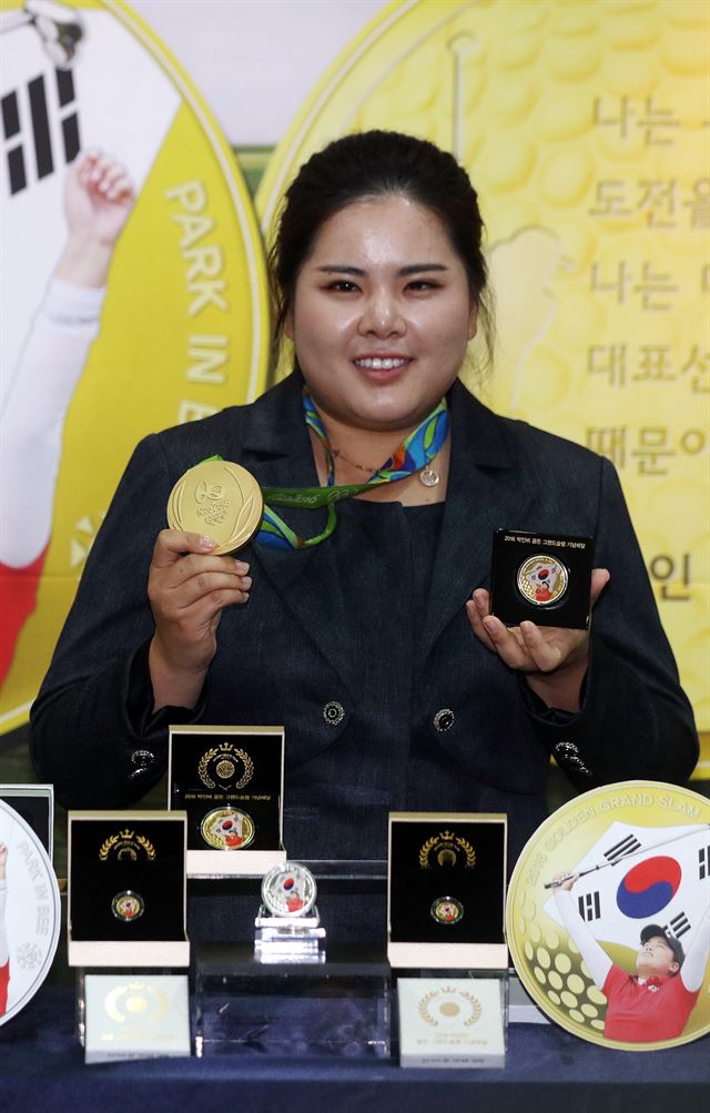 지난 10일 오전 서울 마포구 한국조폐공사에서 프로골퍼 박인비가 골든 그랜드슬램 기념메달을 들고 기념촬영을 하고 있다. 500장 한정으로 출시한 31.1g 금메달 가격은 330만원, 1,000장 한정의 3.75g 금메달은 46만원, 그리고 1,000장 한정 31.1g 은메달은 15만4,000원에 판매된다. 연합뉴스