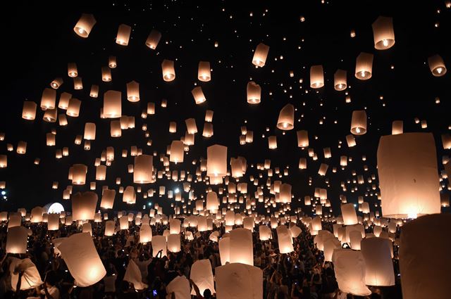 태국 치앙마이에서 14일(현지시간) 이벵 축제(Yi Peng Festival)가 열리고 있는 가운데 시민들이 '꼼러'라 불리는 풍등을 하늘로 날려보내고 있다. AFP 연합뉴스