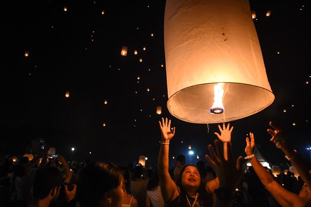 태국 치앙마이에서 14일(현지시간) 이벵 축제(Yi Peng Festival)가 열리고 있는 가운데 시민들이 '꼼러'라 불리는 풍등을 하늘로 날려 보내고 있다. AFP 연합뉴스