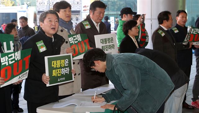 국민의당 안철수 전 대표가 15일 서울역에서 열린 박근혜 대통령 퇴진 서명운동에 참여해 시민들의 동참을 호소하고 있다. 연합뉴스