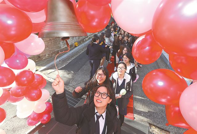 '2018학년도 대학수학능력시험'을 하루 앞둔 16일 오전 광주 남구 설월여고에서 수험표를 수령하고 수능 예비소집 학교로 이동하는 고3 수험생들이 후배들의 응원을 받으며 종을 울리고 있다. 연합뉴스