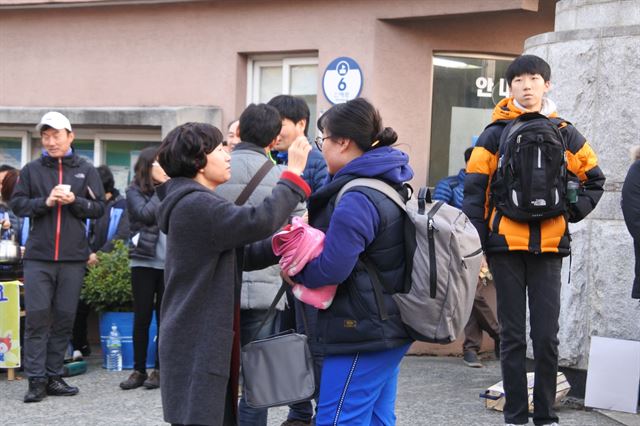 17일 오전 대구 시지고 앞에서 눈가가 촉촉해진 어머니가 딸을 쓰다듬어 주고 있다. 윤희정기자 yooni@hankookilbo.com