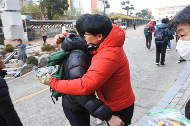 17일 오전 7시 대구 청구고등학교 앞에서 한 선생님이 수험장으로 들어가는 제자를 안아 격려하고 있다. 배유미기자 yum@hankookilbo.com