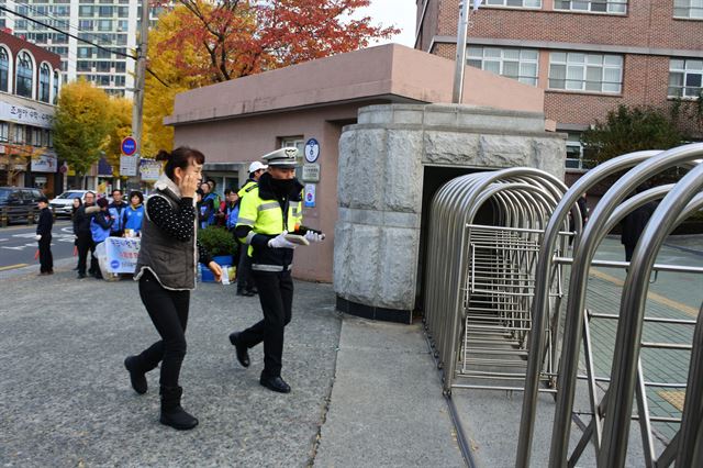 “우리 아이가 신분증을 놓고 갔어요. 꼭 부탁드립니다.” 한 학부모의 다급한 부탁에 경찰이 대신 신분증을 들고 대구 시지고 시험장으로 향하고 있다. 윤희정기자 yooni@hankookilbo.com