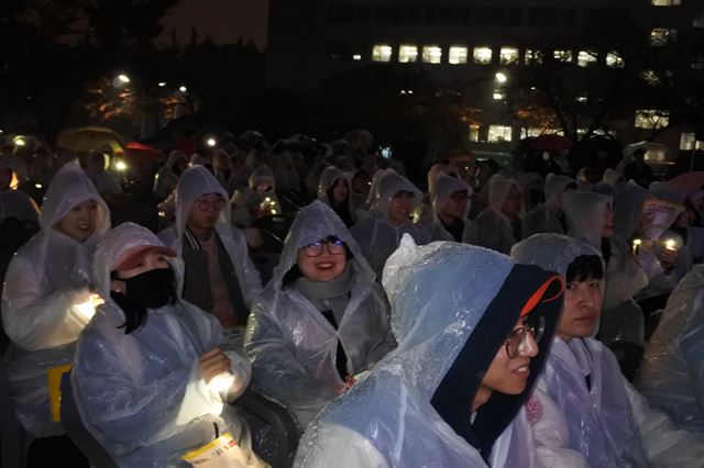 대구경북지역 대학 시국대회 참가자들이 휴대전화 플래시를 켜고 대회장을 밝히고 있다. 윤희정기자 yooni@hankookilbo.com