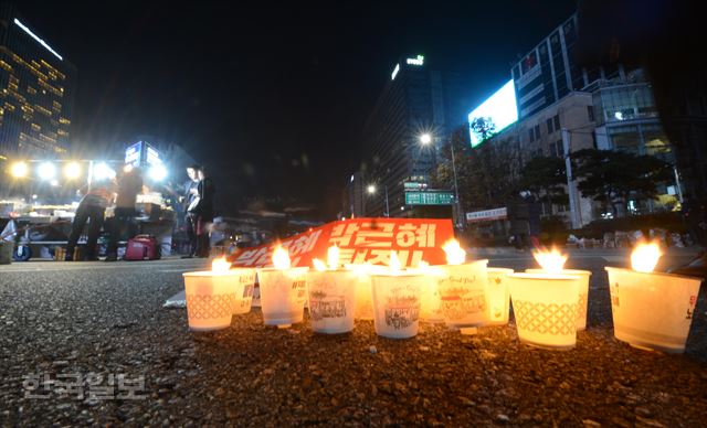 [저작권 한국일보] 12일 저녁 서울 청계광장에서 박근혜 대통령 퇴진을 요구하는 민중총궐기 대회가 끝나고 돌아가던 시민들이 바닥에 모인 촛불과 박근혜 퇴진이라 적힌 피켓이 길위에 놓여 있다. 홍인기 기자 /2016-11-13(한국일보)