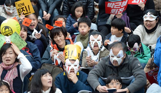 제4차 대통령 하야 촉구 집회가 열린 19일 광화문광장에서 시민들이 가면을 쓰고 참가해 행사를 바라보고 있다.