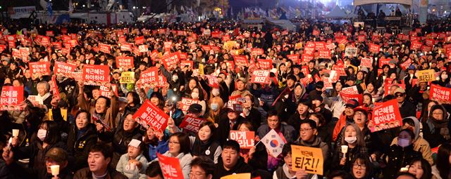 제4차 박근혜 대통령 하야 촉구 집회가 열린 19일 광화문광장에서 시민들이 촛불을 켜들고 피켓을 들어 하야 촉구 구호를 외치고 있다. 오대근기자