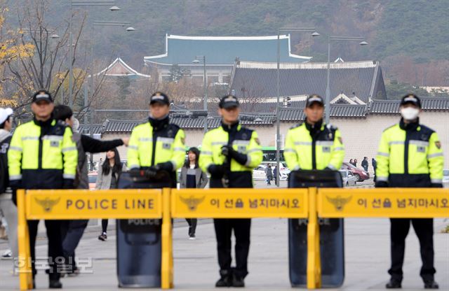 21일 오후 서울 광화문광장에서 전국 대학생 시국회의 회원들이 박근혜 정권 퇴진을 위한 전국 대학생 동맹휴업을 제안하는 기자회견을 하는 가운데 경찰들이 청와대 방향에서 경비를 서고 있다. 홍인기 기자