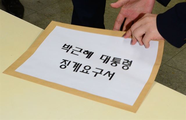 새누리당 비박계가 주도하는 비상시국위원회가 박근혜 대통령의 징계요구서를 21일 당 사무처에 냈다. 여기에는 현직 국회의원 29명과 원외 당협위원장 7명이 동의했다. 새누리당 기조국에 제출된 징계요구서를 당직자가 집어들고 있다. 오대근 기자 inliner@hankookilbo.com