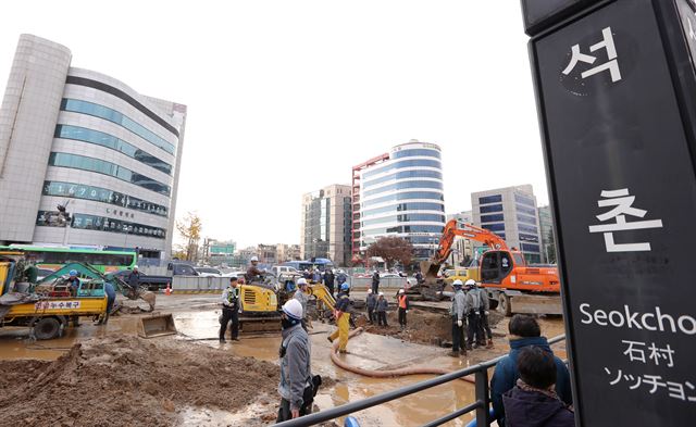 22일 오후 서울 송파구 석촌역 사거리에서 소방 및 공사 관계자들이 상수도관 파열로 물바다가 된 도로를 복구 작업하고 있다. 소방당국 등에 따르면 이날 사고는 오후 1시 45분께 서울 송파구 석촌역 9호선 공사를 하던 중 4번 출구 쪽 상수도관이 파열돼 발생한 것으로 추정된다. 2016.11.22 연합뉴스