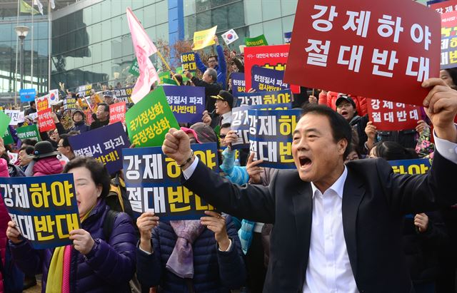 박근혜 대통령의 팬클럽인 박사모를 비롯한 보수단체 회원들이 19일 오후 서울 중구 서울역광장에서 박근혜 대통령 하야를 반대하는 집회를 열고 구호를 외치고 있다. 뉴시스