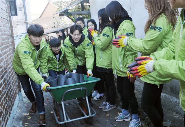 순천향대 홍보대사 '알리미' 학생들이 축제수익금으로 마련한 연탄을 아산지역 저소득층 가정에 배달하고 있다. 순천향대 제공