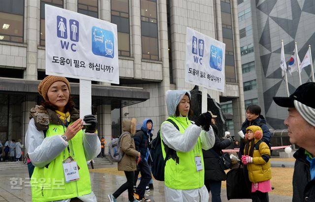 박근혜 대통령 퇴진 요구 민중총궐기 촛불집회가 열린 26일 오후 서울시에서 나온 안내원들이 시민들 편의를 위해 화장실 등을 안내하고 있다. 김주성기자 poem@hankookilbo.com