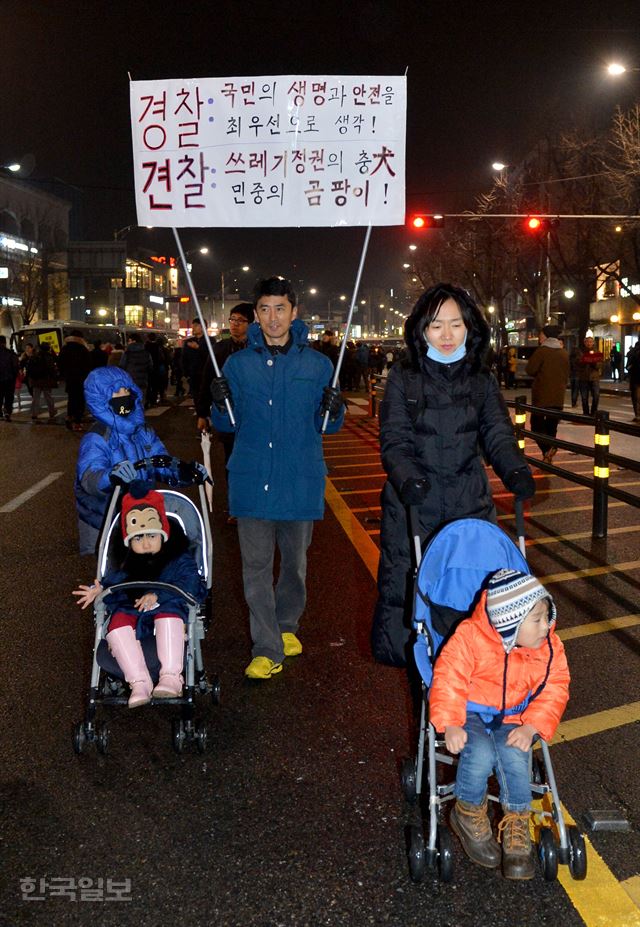 박근혜 대통령 퇴진 요구 대규모 촛불집회가 열린 26일 서울 청운동 주민센터에 한 가족이 나와 행진을 하고 있다. 김주성기자 poem@hankookilbo.com