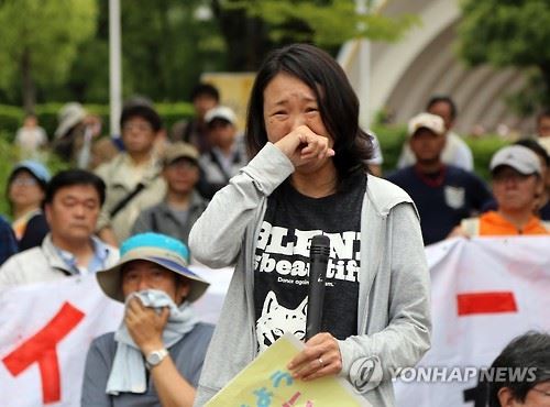 [가와사키=연합뉴스 자료사진] 혐한 시위 반대 여론의 기폭제 역할을 한 일본 가나가와(神奈川)현 가와사키(川崎)시의 재일동포 3세 최강이자(42)씨가 지난 6월 5일 가와사키시에서 시민들과 함께 혐한 시위 항의 활동을 벌인 뒤 발언하다 감격의 눈물을 흘리고 있다. 혐한 시위대는 이날 행진을 시도하다 시민들의 거센 항의에 약 40분 만에 중단을 선언했다.