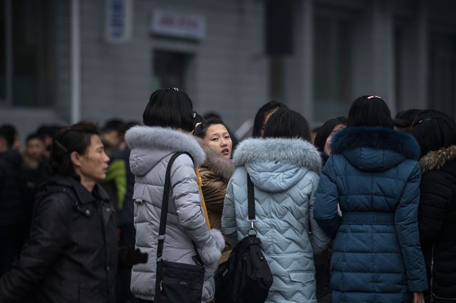 북한 평양에서 27일 다양한 디자인과 색깔의 겨울 옷을 입은 여성들이 거리에 모여 있다. AFP 연합뉴스