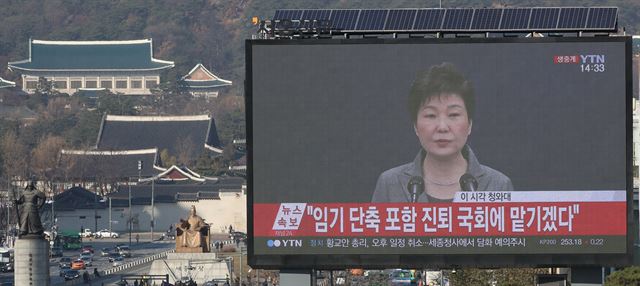 박근혜 대통령이 제3차 대국민담화를 발표한 29일 오후 서울 중구 프레스센터 앞에 설치된 전광판에 박 대통령의 담화문 발표 모습이 비치고 있다. 전광판 왼쪽으로 청와대가 보인다. 연합뉴스