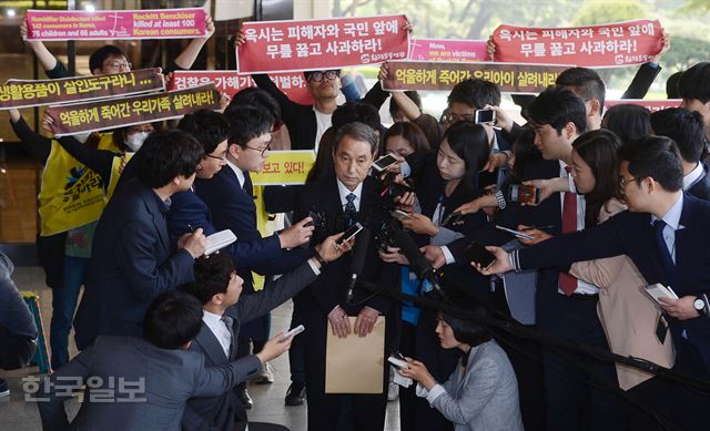 4월 26일 오전 서초동 서울중앙지검에서 신현우 옥시 전 대표이사가 취재진의 질문에 답변하는 동안 피해자 가족과 환경운동연합 회원들이 피켓시위를 벌이고 있다. 고영권기자