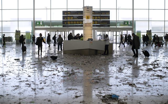 스페인 프라트 리오브레가트의 바르셀로나 공항 청소원들의 파업 4일째를 맞은 1일(현지시간) 승객들이 청소원들이 시위 중 던진 종이와 쓰레기가 쌓여 있는 공항을 걷고 있다. AP 연합뉴스