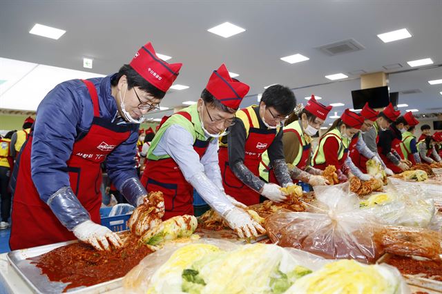 김명우(왼쪽서 두 번째) 두산중공업 사장이 3일 두산중공업 창원공장 사내식당에서 열린 '2016 사랑의 김장 나누기'행사에서 봉사단 300여명과 김치를 담그고 있다. 두산중공업 제공