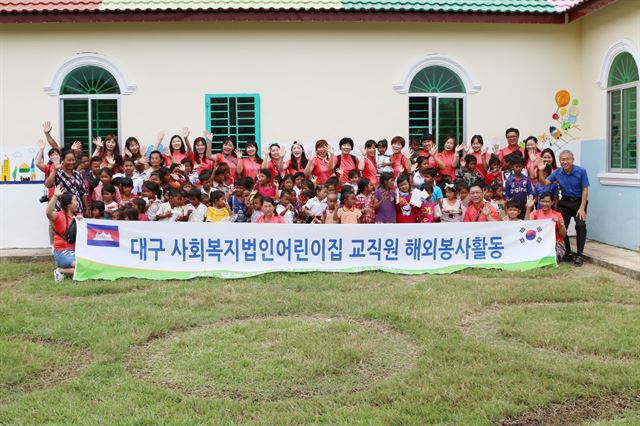 대구 법인어린이집 교사들이 캄보디아 껌퐁톰시 오쿤도 마을 '평화어린이집'을 방문해 기념촬영을 하고 있다.