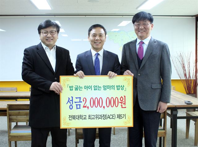 전북대 최고위과정 제5기 원우회 서성진(왼쪽) 봉사위원장과 최백렬(오른쪽) 전북대 상과대학장이 김승수 전주시장에게 성금을 전달한 뒤 기념촬영을 했다. 전북대 제공