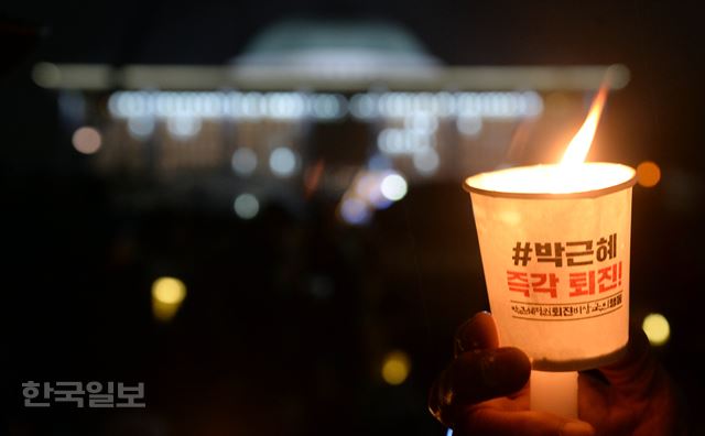 박근혜 대통령에 대한 탄핵표결을 하루 앞둔 8일 저녁 서울 여의도 국회 정문앞에서 시민들이 촛불을 들고 집회를 하고 있다. 서재훈기자 spring@hankookilbo.com