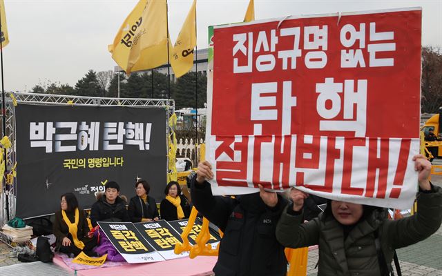 박근혜 대통령 탄핵소추안 표결을 하루 앞둔 8일 오후 국회 앞에서 한 기독교계 보수단체의 탄핵반대 집회 참가자들이 피켓을 들고 있다. 왼쪽은 탄핵찬성 연좌농성 중인 정의당 당원들. 연합뉴스