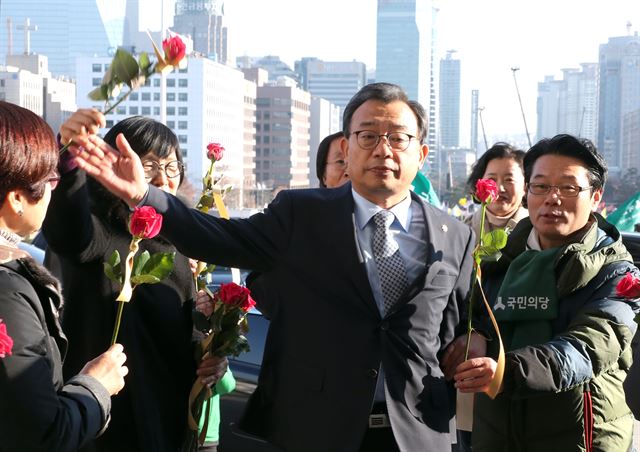 새누리당 이정현 대표가 9일 오후 국회 본회의장에서 열린 박근혜 대통령의 탄핵소추안에 대한 표결을 위해 입장하다 환경운동연합 등 시민단체 회원들이 전달하는 '탄핵찬성 촉구' 꽃다발을 뿌리치고 있다. 꽃다발에는 "촛불을 기억하세요". "탄핵에 찬성하세요"란 글귀가 쓰여 있다. 이날 실시된 대통령 탄핵안 표결은 [찬성 234:반대 56]으로 가결되었다. 2016.12.9 서울=연합뉴스