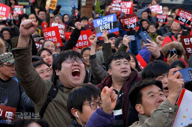 박근혜 대통령 탄핵안이 국회에서 가결된 9일 서울 여의도 국회의사당 앞에 모인 시민들이 환호하고 있다. 김주성 기자