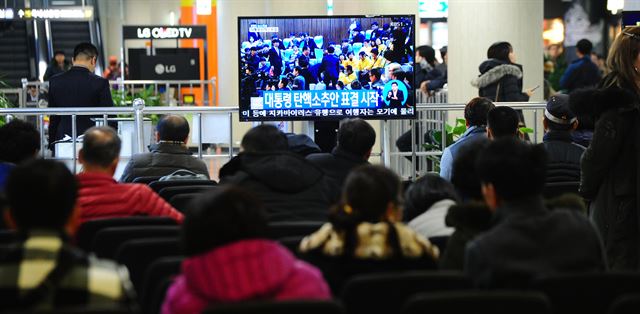 박근혜 대통령 탄핵 표결이 열린 9일 오후 제주시 제주국제공항 대합실에서 공항 이용객들이 TV를 통해 대통령 탄핵안 표결을 지켜보고 있다. 뉴스1