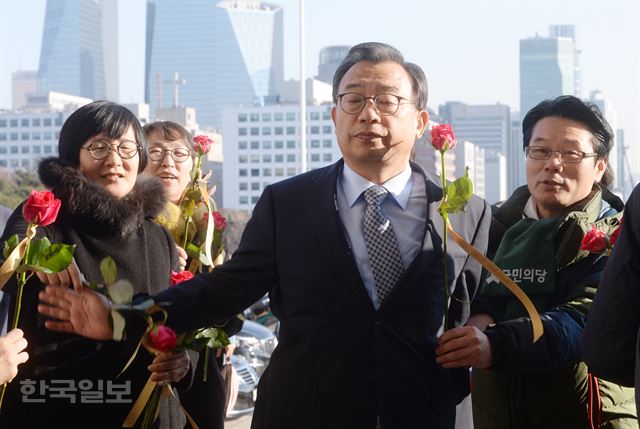 이정현 새누리당 대표가 9일 국회 본회의장에서 열린 박근혜 대통령의 탄핵소추안에 대한 표결을 위해 입장하다 환경운동연합 등 시민단체 회원들이 전달하는 '탄핵찬성 촉구' 꽃다발을 손으로 쳐내고 있다. 꽃다발에는 "촛불을 기억하세요". "탄핵에 찬성하세요"란 글귀가 쓰여 있다. 배우한 기자 bwh3140@hankookilbo.com