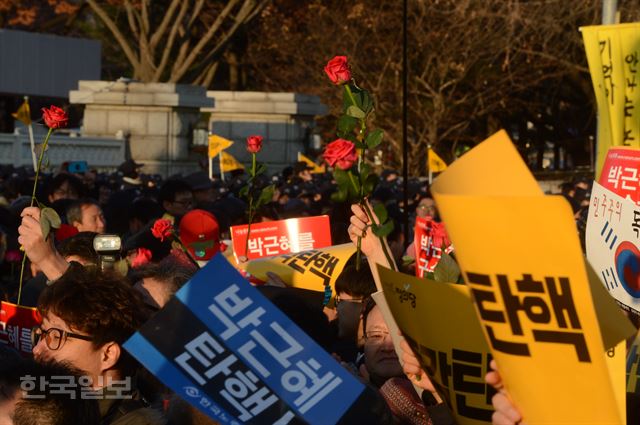 [저작권 한국일보] 박근혜대통령 에 대한 탄핵소추안 표결이 국회에서 가결 되었다는 소식이 전해진 9일 오후 서울 여의도 국회앞에서 탄핵 개표 결과를 기다리던 시민들이 꽃을 들고 환호성을 지르며 탄핵안 통과를 기뻐 하고 있다. 신상순 선임기자ssshin@hankookilbo.com /2016-12-09(한국일보)