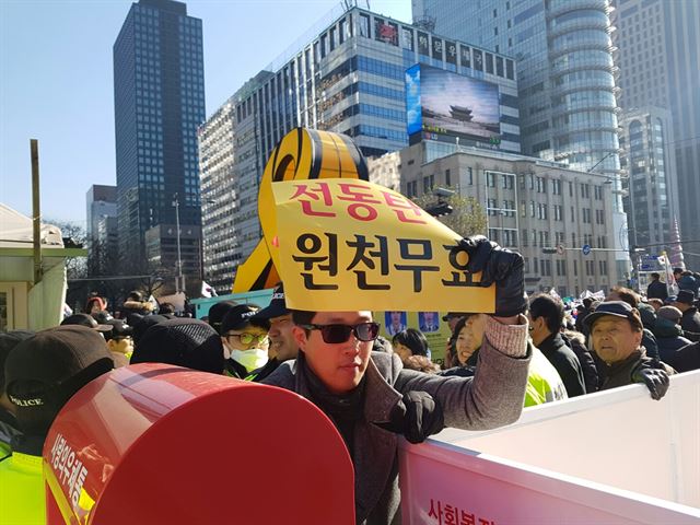 한 보수단체 회원인 10일 오전 서울 종로구 동아일보사 앞에서 박근혜 대통령 탄핵에 반대하는 손팻말을 들고 있다. 정반석 기자