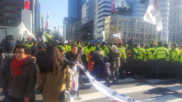 10일 낮 서울 광화문 사거리 일대를 점거한 보수단체 회원들이 대형 태극기 인간띠를 만들고 경찰과 대치하고 있다. 양진하 기자