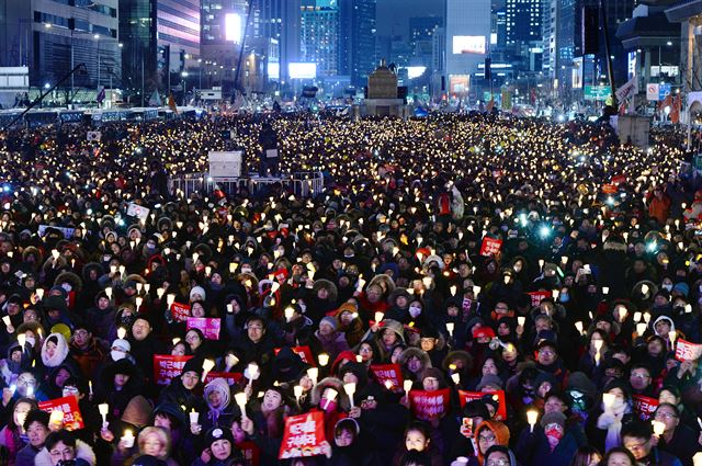 박근혜 대통령 탄핵소추안이 가결된 다음 날인 10일 광화문 광장에 모인 시민이 촛불을 밝히고 '박근혜 대통령 즉각 퇴진' 구호를 외치고 있다. 왕태석기자 kingwanag@hankookilbo.com