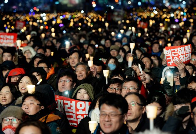 박근혜 대통령 탄핵소추안이 가결된 다음 날인 10일 광화문 광장에 모인 시민이 촛불을 밝히고 '박근혜 대통령 즉각 퇴진' 구호를 외치고 있다. 왕태석기자 kingwanag@hankookilbo.com